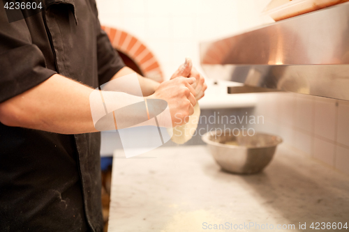 Image of chef hands preparing dough on table at kitchen