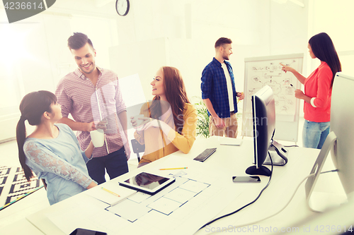 Image of happy creative team rinking coffee at office