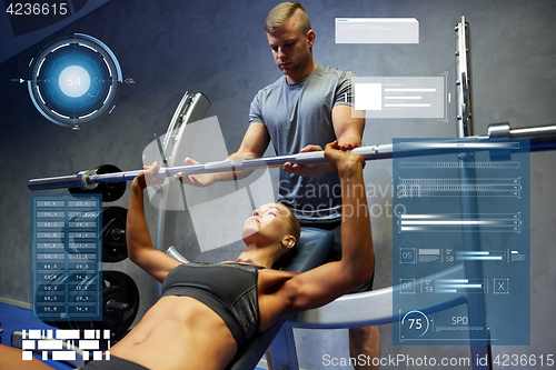 Image of man and woman with barbell flexing muscles in gym