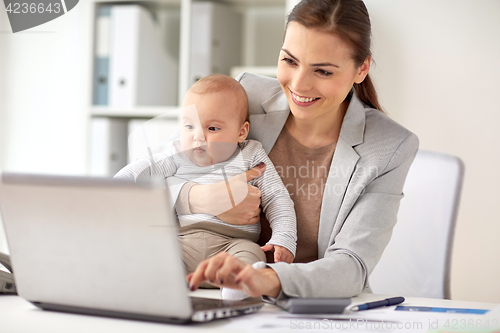 Image of happy businesswoman with baby and laptop at office
