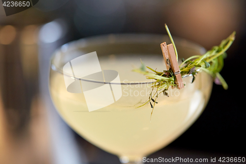 Image of close up of glass with cocktail at bar