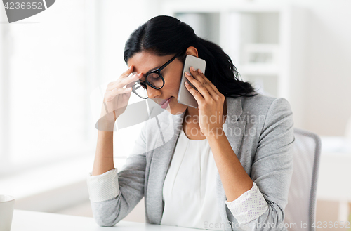 Image of stressed businesswoman with smartphone at office