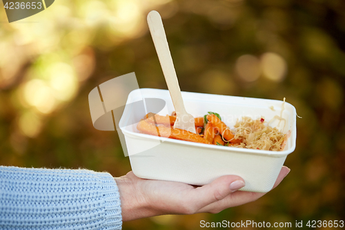 Image of close up of hand holding plate with sweet potato