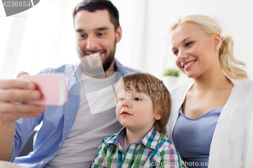 Image of happy family with smartphone at home