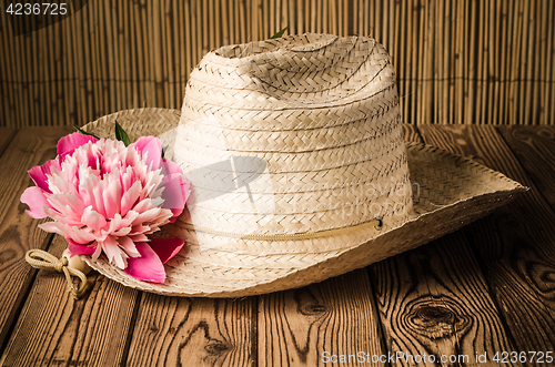 Image of Straw hat and peony flower, close-up