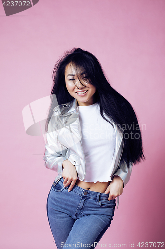 Image of young pretty smiling asian korean girl wearing modern fashion clothers on pink background, lifestyle people concept 