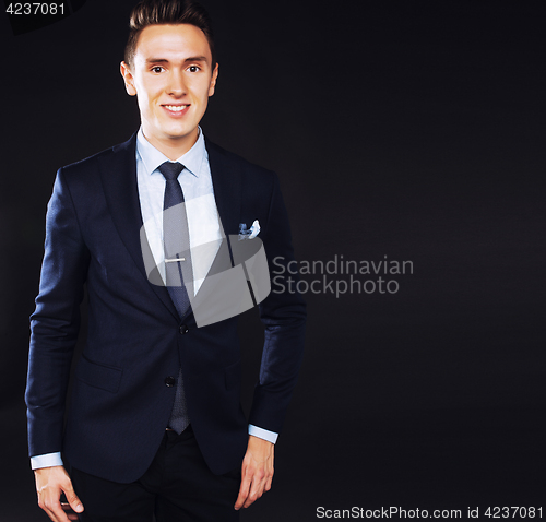 Image of young pretty business man standing on black background, modern h