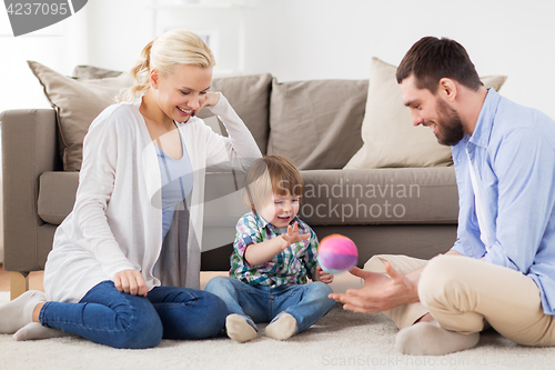 Image of happy family playing with ball at home