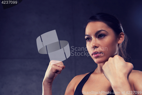 Image of woman holding fists and fighting in gym