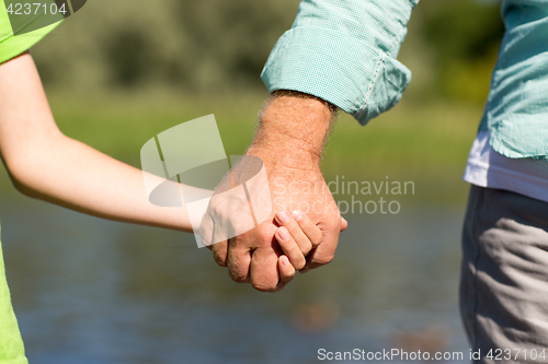 Image of senior man and child holding hands