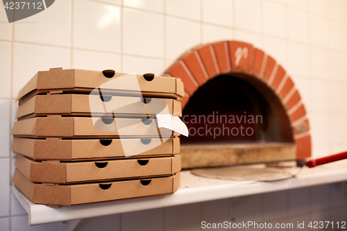 Image of close up of pizza in box on table at pizzeria oven