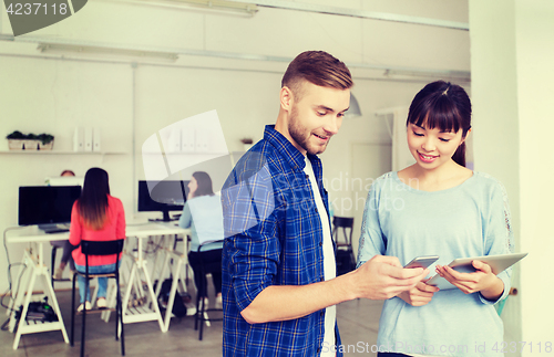 Image of couple with smartphone and tablet pc at office