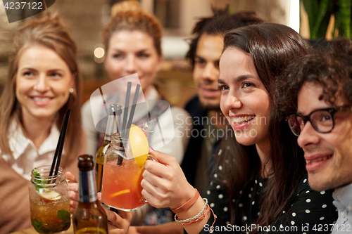 Image of happy friends with drinks at bar or cafe