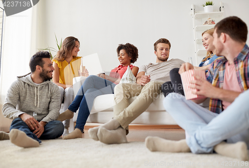 Image of happy friends with popcorn and beer at home
