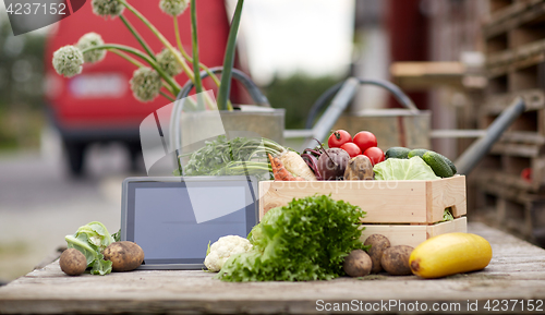 Image of close up of vegetables with tablet pc on farm