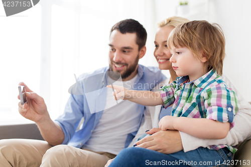 Image of happy family with smartphone at home