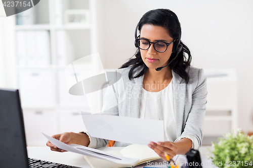 Image of businesswoman with headset and computer at office