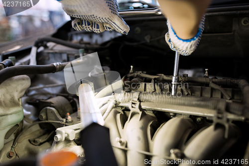 Image of mechanic man with wrench repairing car at workshop