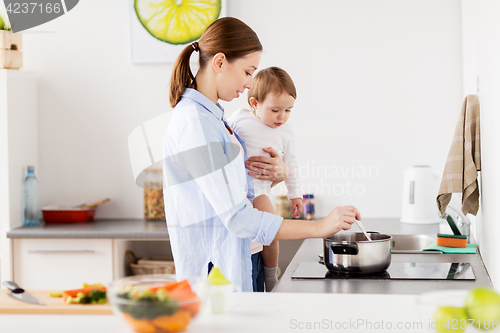 Image of happy mother and baby cooking at home kitchen