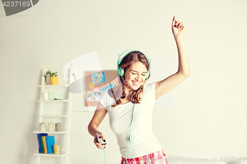 Image of happy woman in headphones ihaving fun at home