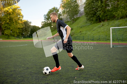 Image of soccer player playing with ball on football field