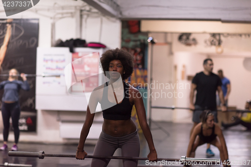 Image of black woman lifting empty bar