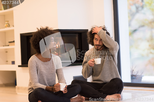 Image of multiethnic couple  in front of fireplace