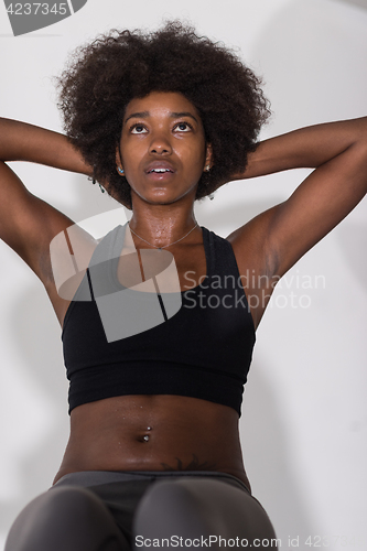 Image of black woman doing sit ups at the gym
