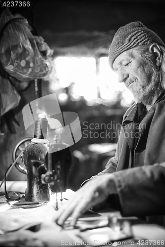 Image of Man with sewing machine bw