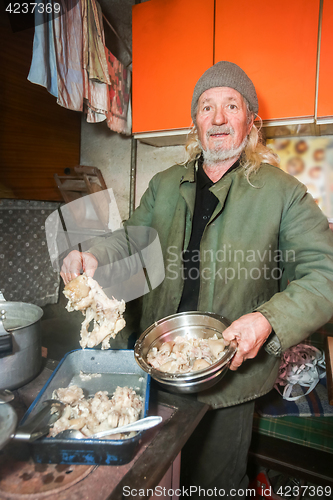 Image of Man preparing pork for lunch