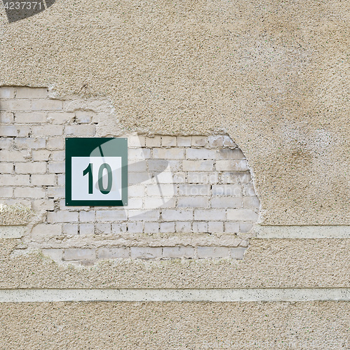 Image of brick wall and plate with a number ten