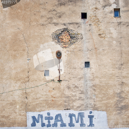 Image of cracked brick wall with graffiti