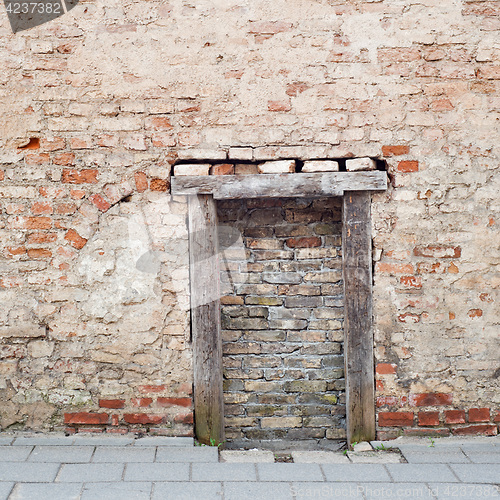 Image of cracked brick wall with bricked up doorway