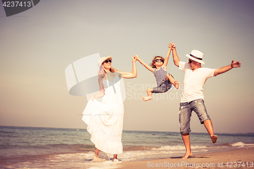 Image of Happy family walking on the beach at the day time.