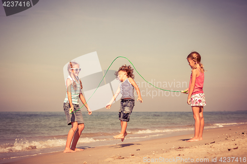 Image of Three happy children playing on the beach