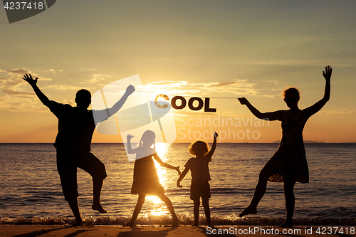 Image of Happy family standing on the beach