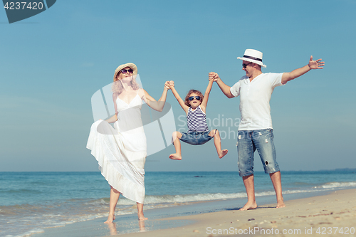 Image of Happy family walking on the beach at the day time.