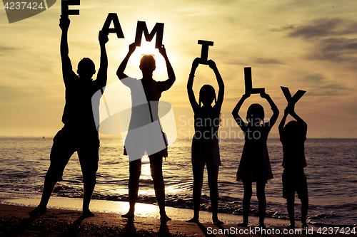 Image of Happy family standing on the beach