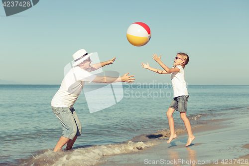 Image of Father and daughter playing on the beach.