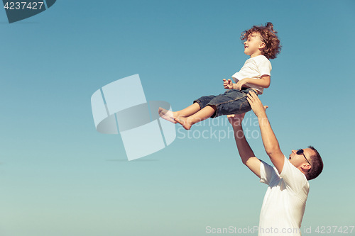 Image of Father and son playing on the beach at the day time.