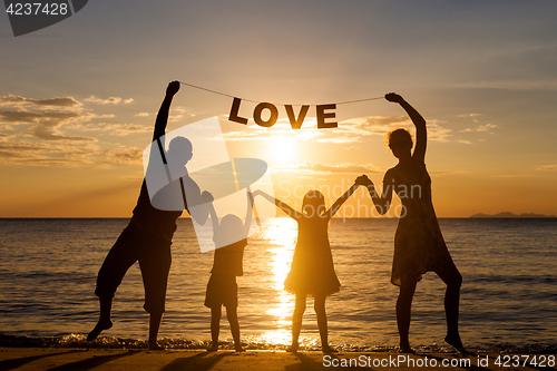Image of Happy family standing on the beach