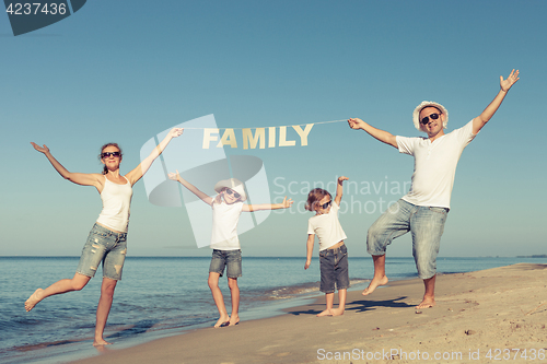 Image of Happy family standing on the beach at the day time.
