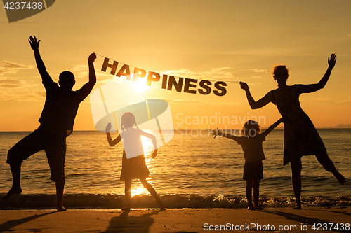 Image of Happy family standing on the beach