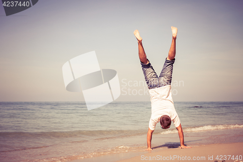 Image of Happy man jumping on the beach