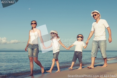 Image of Happy family standing on the beach at the day time.