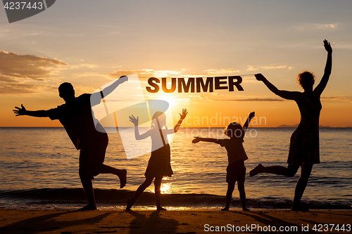 Image of Happy family standing on the beach