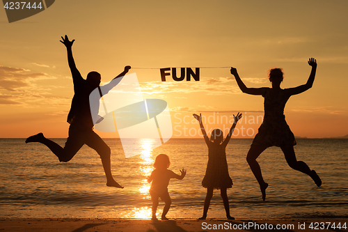 Image of Happy family standing on the beach