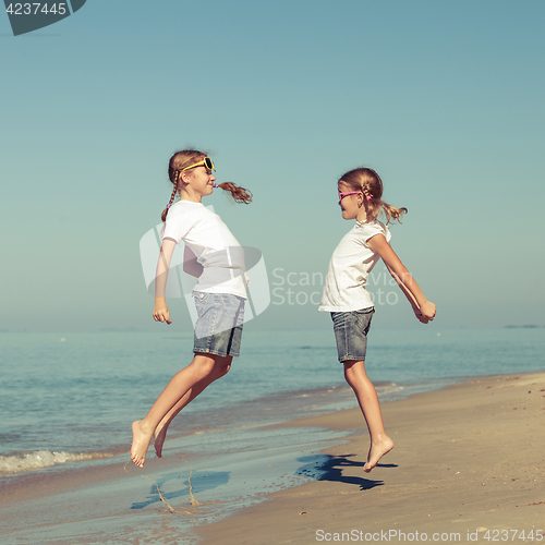 Image of two sisters playing on the beach