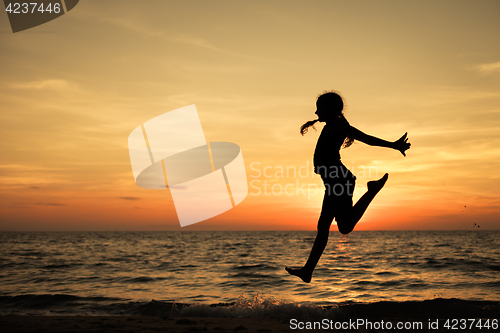 Image of Happy teen girl  jumping on the beach