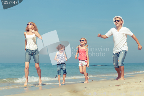 Image of Happy family walking on the beach at the day time.